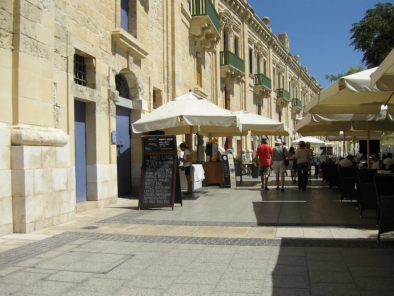 A shaded café terrace on a Valletta street.