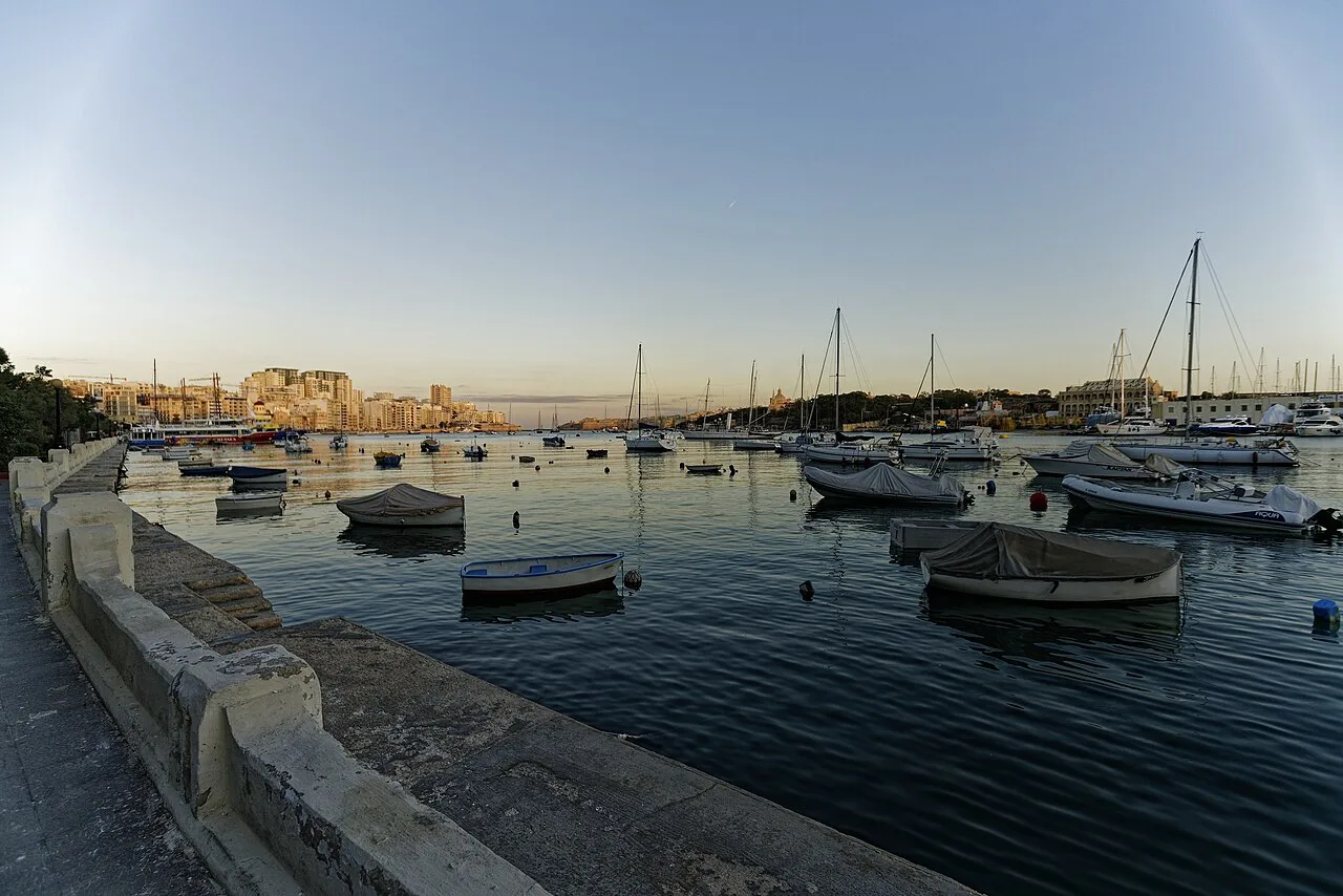 Boats moored in Sliema's harbour at dusk.