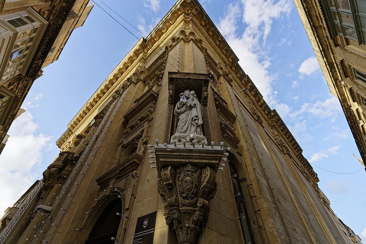 A statue in a niche on a Valletta street corner.