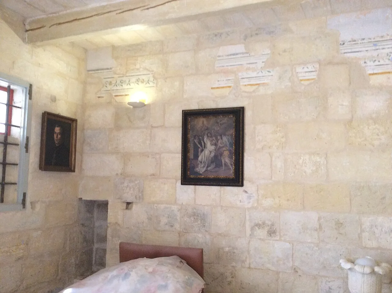 A furnished room with portraits inside the Norman House in Birgu.
