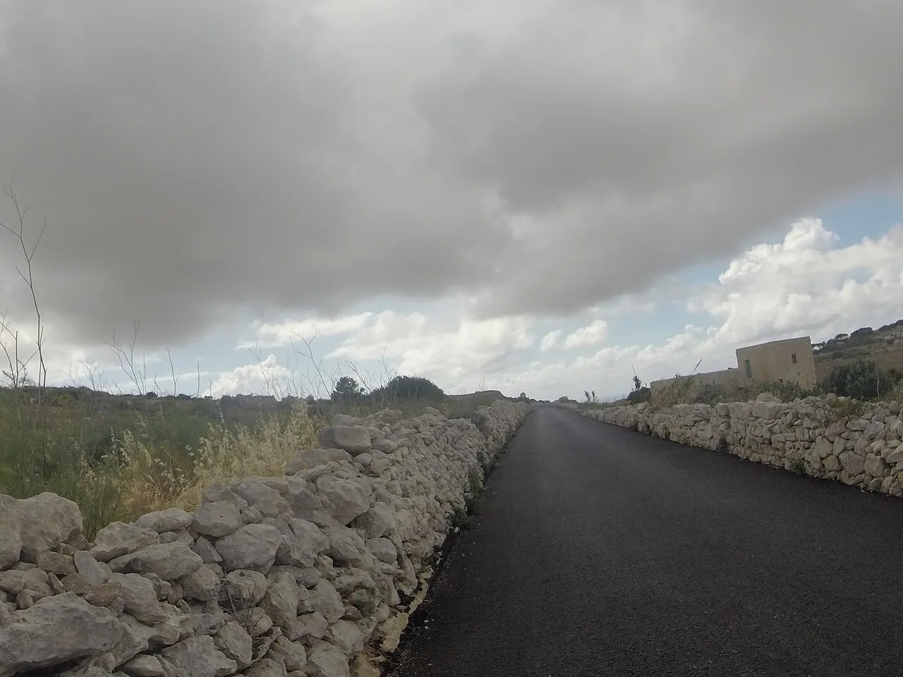 A quiet country road lined with stone walls near Rabat.