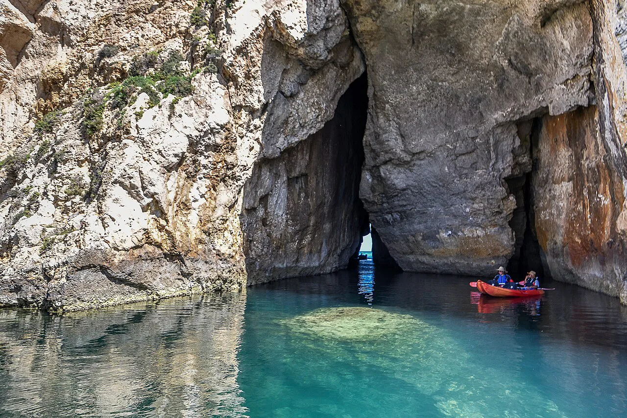 Kayakers entering the sea cave at the Inland Sea, Dwejra, Gozo.