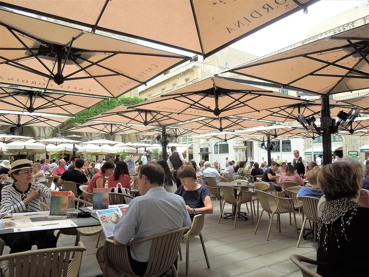 Café tables beneath umbrellas on Pjazza San Pawl in Valletta.