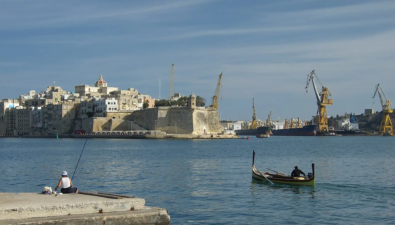 A small boat on Grand Harbour with Senglea behind.