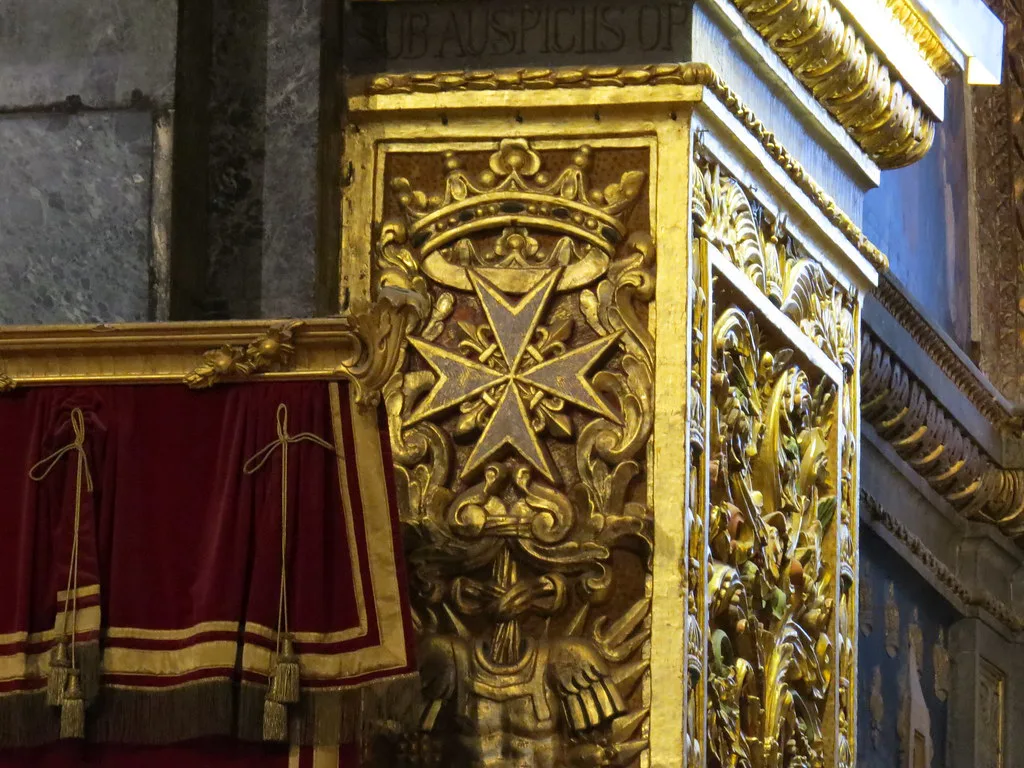 A gilded Maltese cross ornament.
