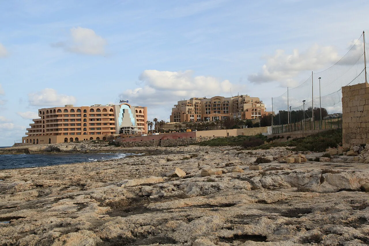 The rocky Pembroke coast with St Julian's hotels beyond.