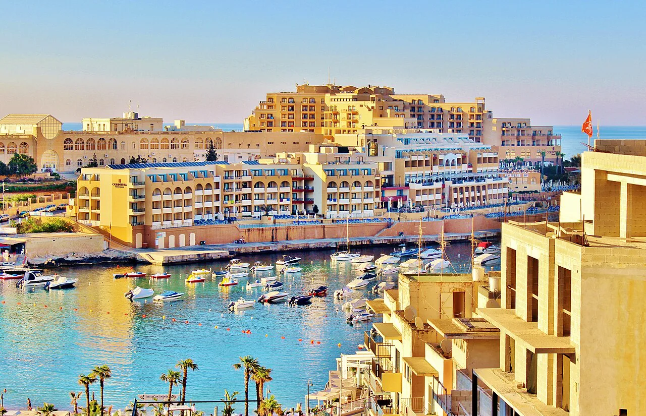Boats in St Julian's Bay, with hotels along the shore.