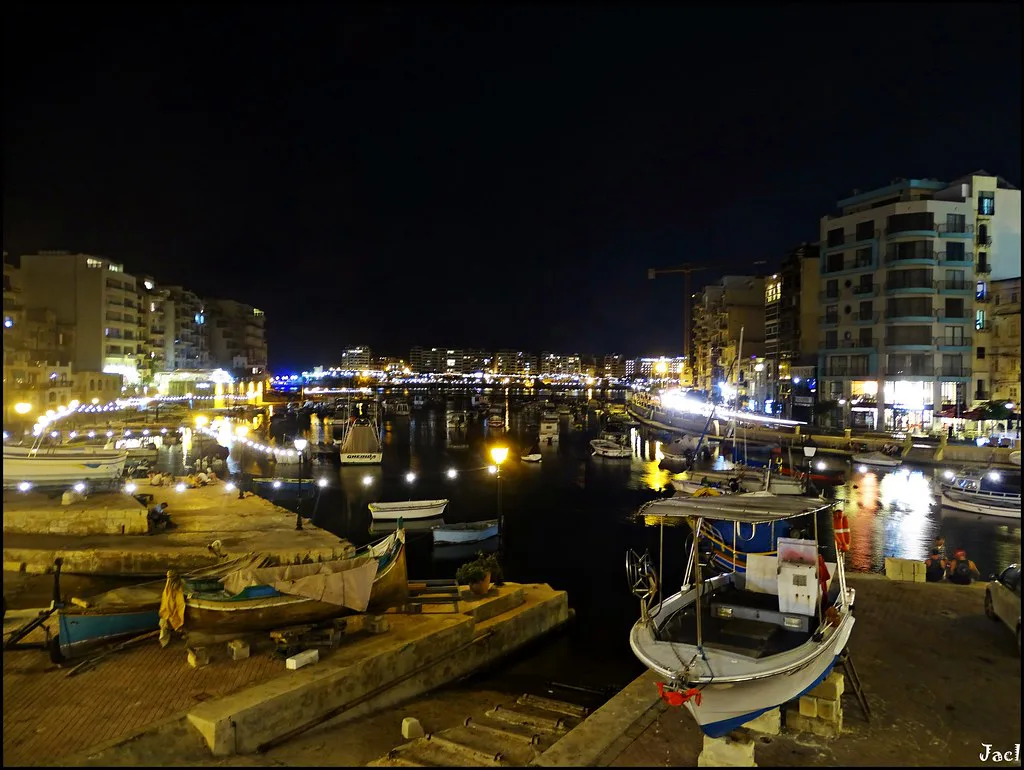 St Julian's harbour lit up at night.