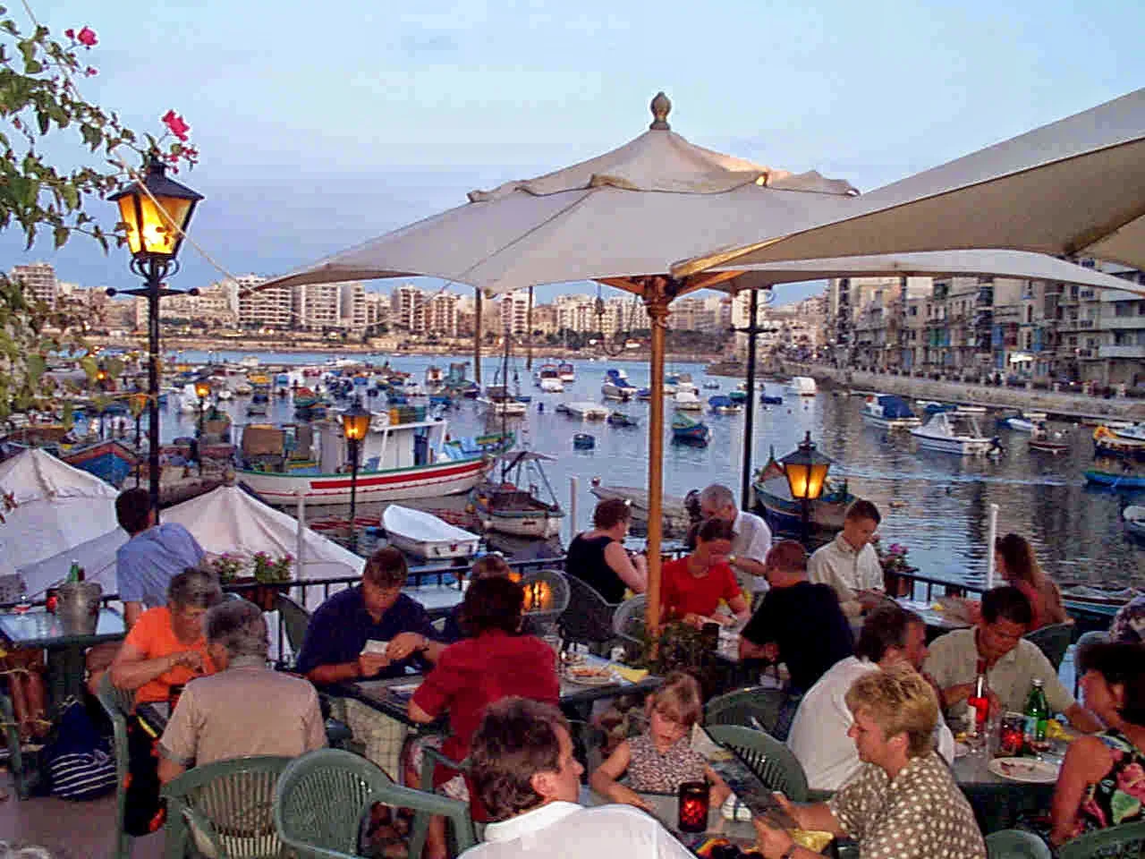 Waterside restaurant tables overlooking a Maltese harbour.